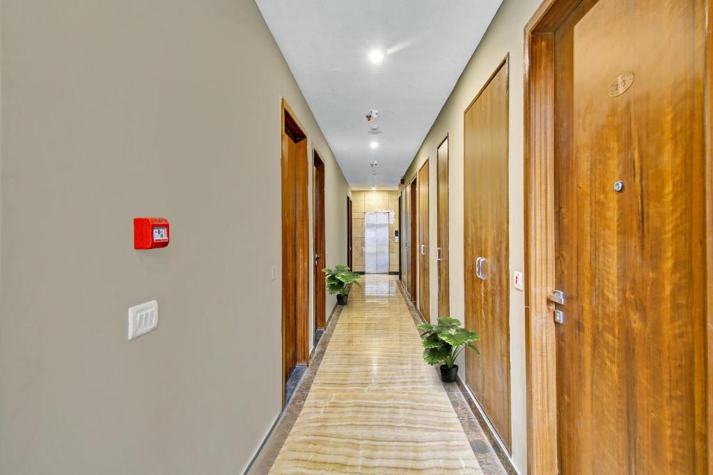 a hallway with wooden doors and potted plants at Townhouse Golden Frame near sec 62 noida in Ghaziabad