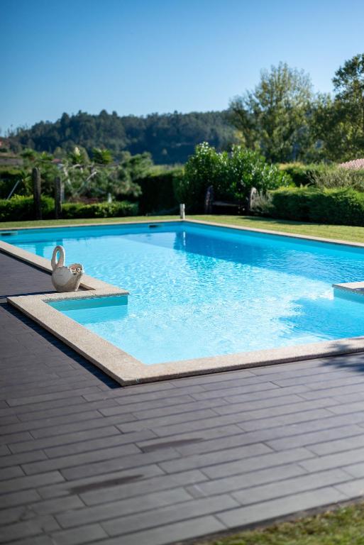 a large swimming pool with blue water at Casa Flor do Campo in Celorico de Basto