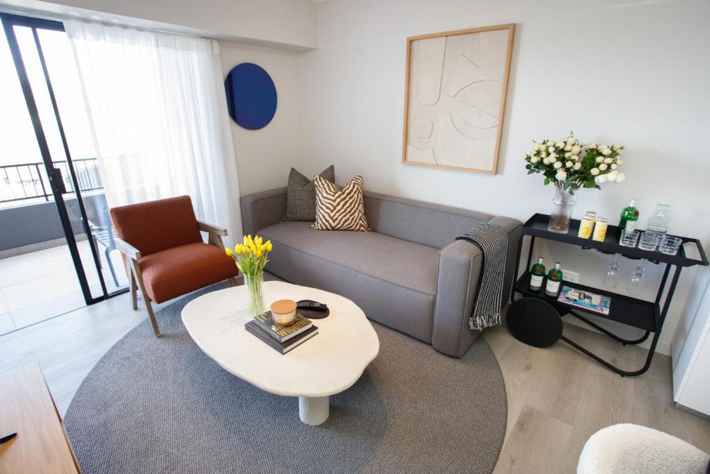 克尼斯纳302 Seahorse - Premium 2 Bedroom Unit with Pool & Parking的客厅里有一张沙发和一张桌子。