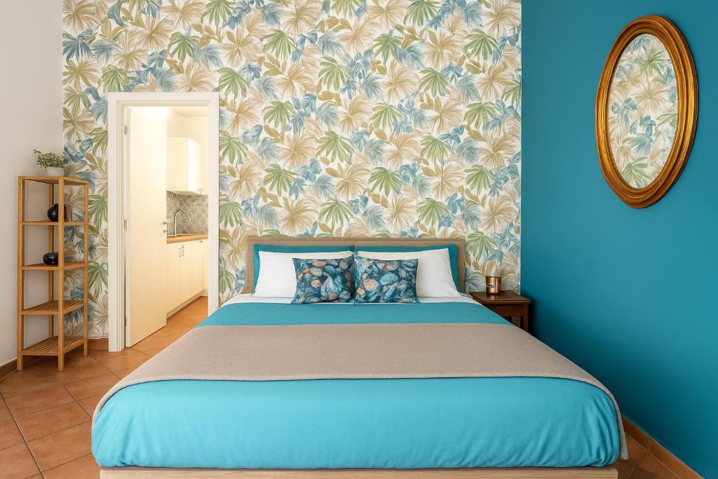 een blauwe slaapkamer met een bed met een blauwe muur bij Sabbie dell'Etna - Eleganza e Comfort nel Cuore di Catania con Parcheggio Privato in Catania