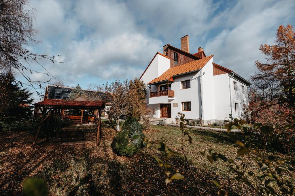 a house with a gazebo in front of it at Szárhegyi Vendégház in Lăzarea
