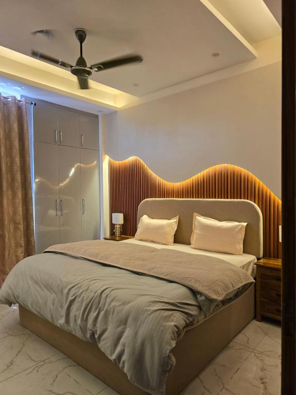 a bedroom with a large bed with an orange headboard at Blissful Escape Dehradun in Dehradun