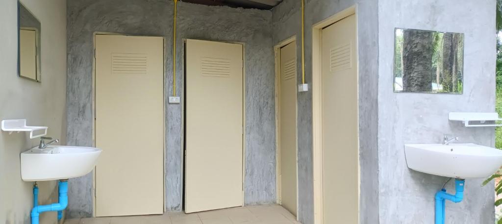 un baño con dos lavabos y dos espejos en Bambu hut, en Phra Ae beach