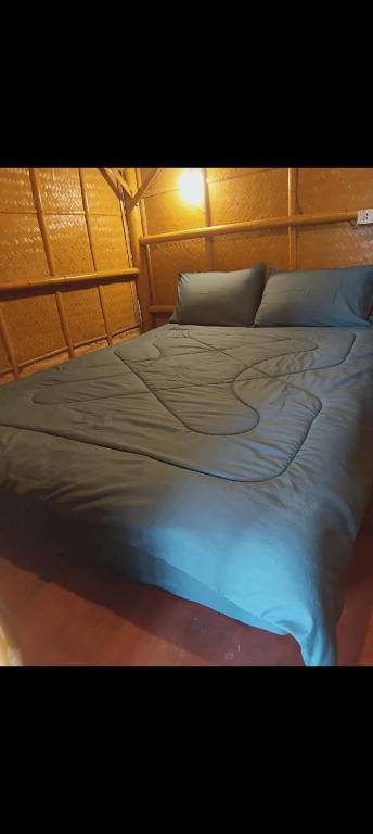 a bedroom with a large bed with a wooden headboard at in the palm hut in Phra Ae beach