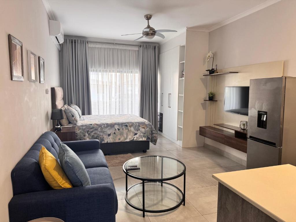 a living room with a couch and a bed at Cozy-corner in Gaborone