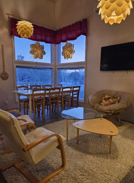 a living room with a table and chairs and a television at Villa Ateljee in Rovaniemi