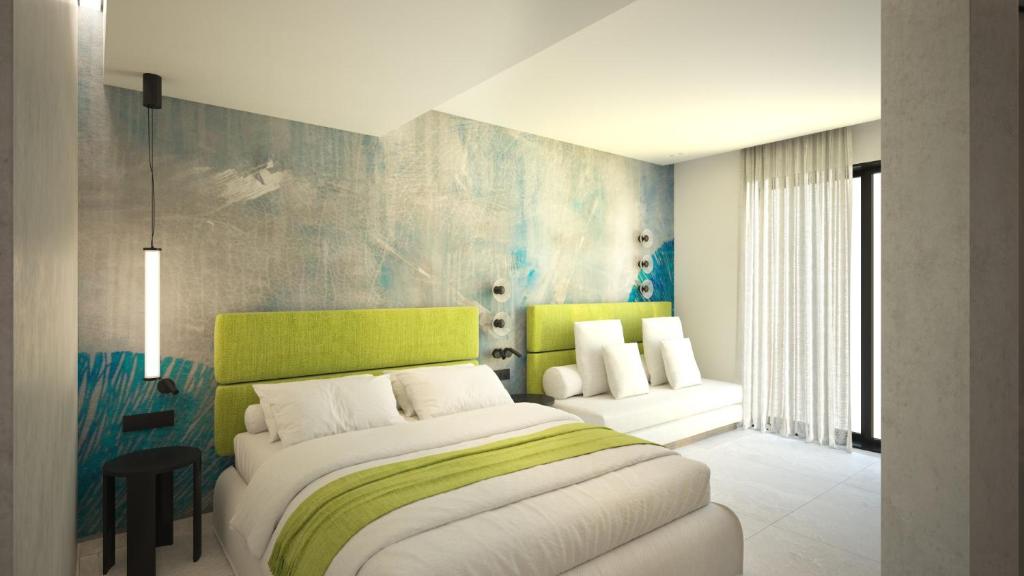 a bedroom with a large bed with a green headboard at Leonidas Hotel & Apartments in Rethymno Town