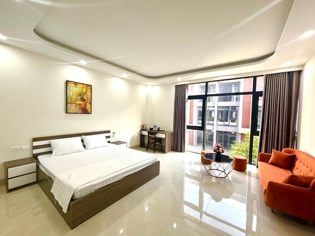 a bedroom with a bed and a couch and a window at Ha Noi Smile Home in Ðình Loan