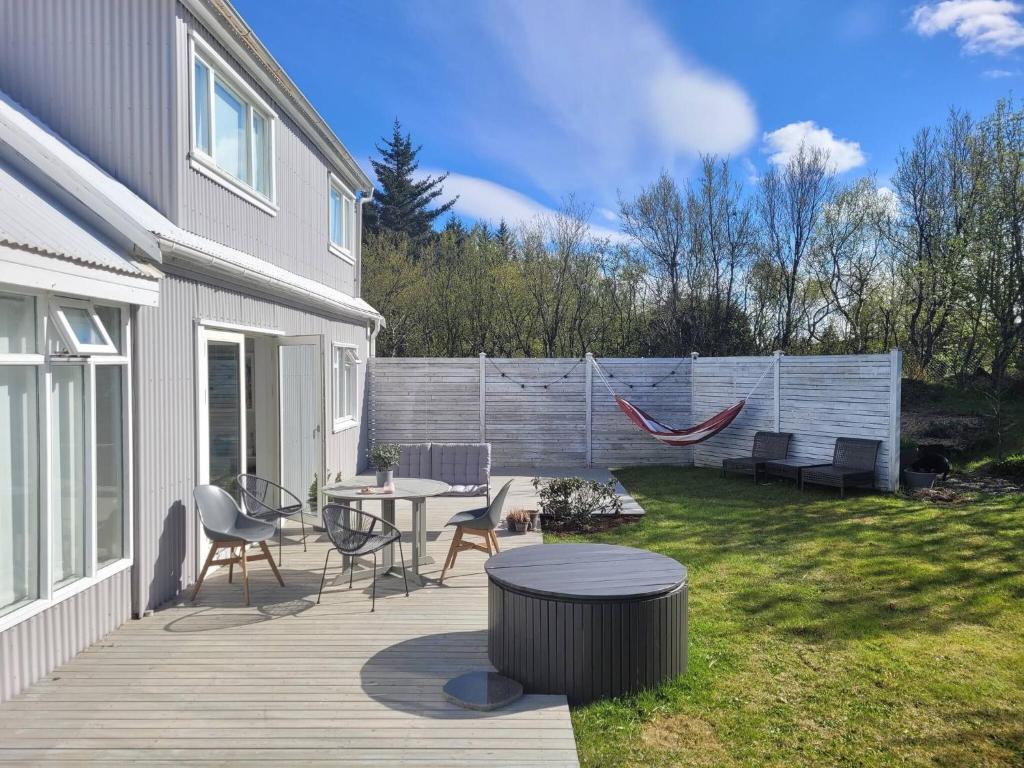 a patio with a table and chairs and a fence at Rustic, Scandinavian house close to Reykjavik in Garðabær