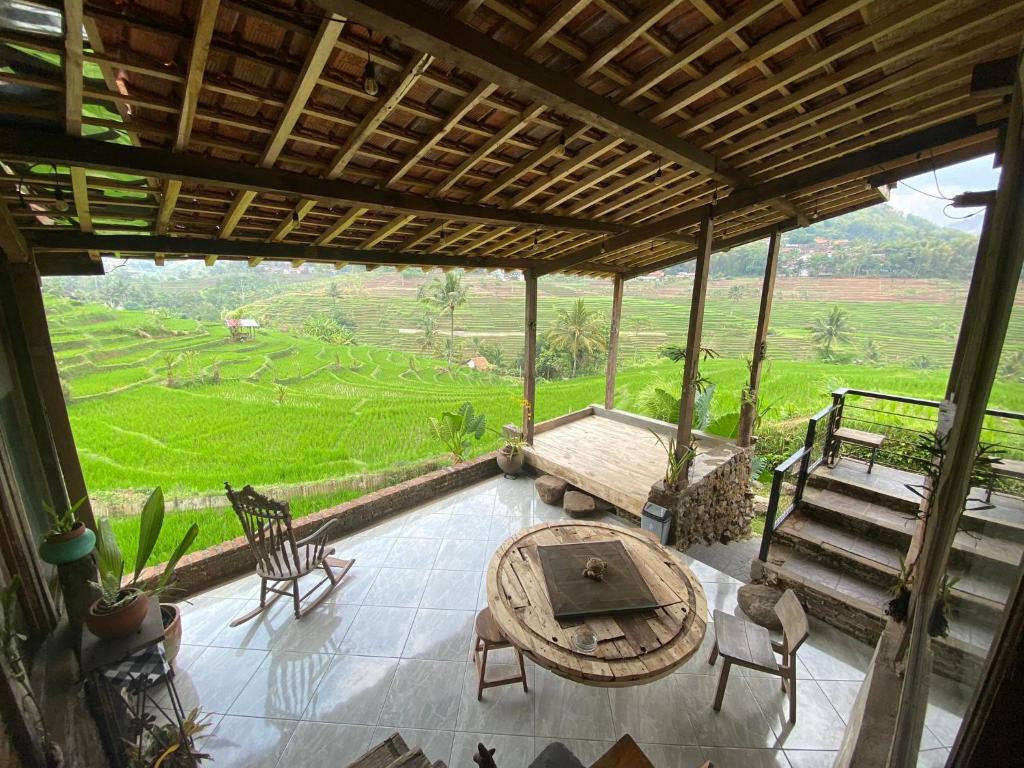 a screened in porch with a table and chairs at Villa Cetok Syariah - Nuansa Pedesaan in Simpen