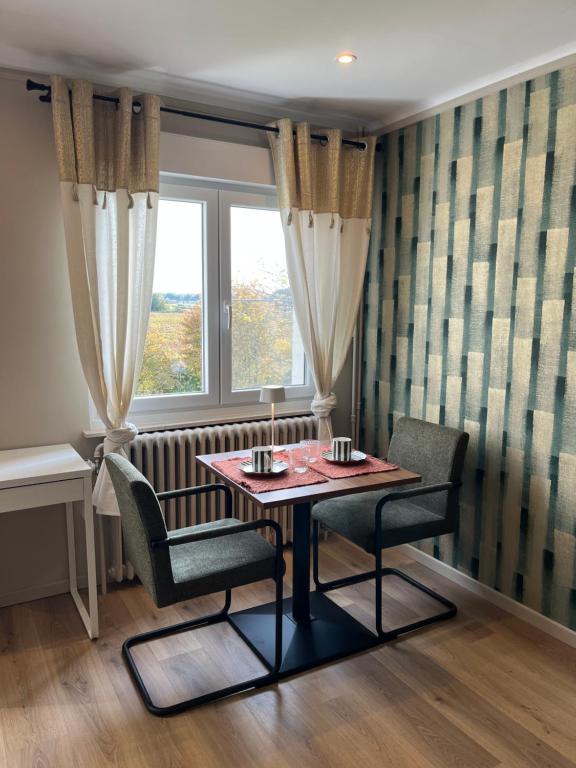 a table and chairs in a room with a window at Chambre d'hôtes Lucia avec vue sur jardin arboré in Tournai