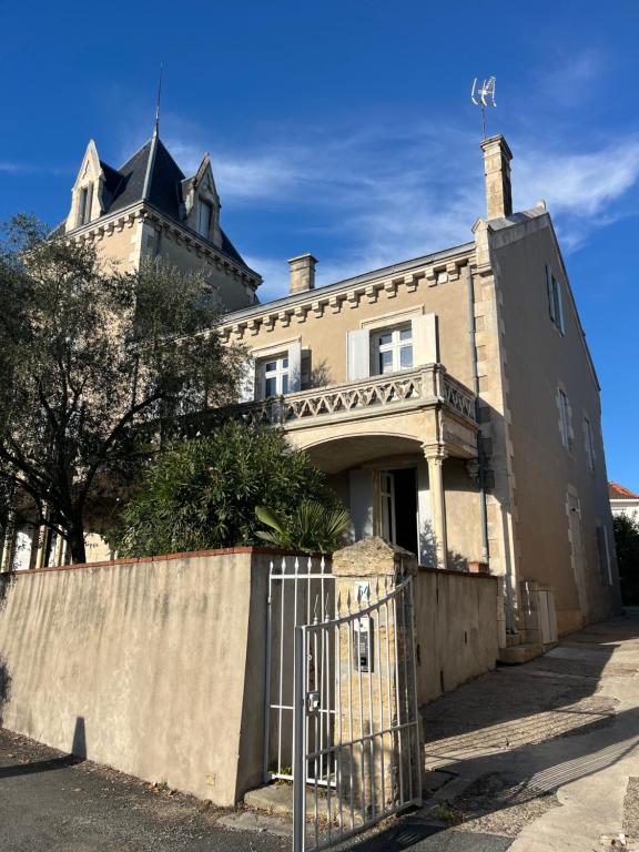 an old house with a fence in front of it at La Tour du Maine in Marmande