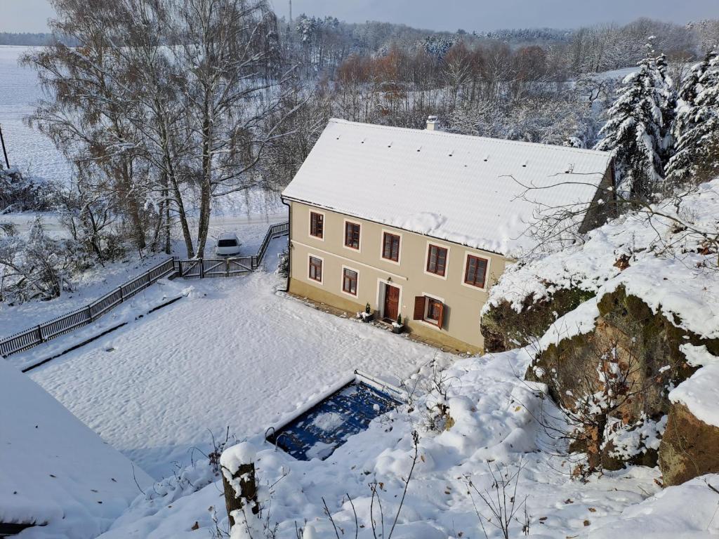 uma casa com um telhado coberto de neve em Chalupa Zátyní - celý objekt em Dubá