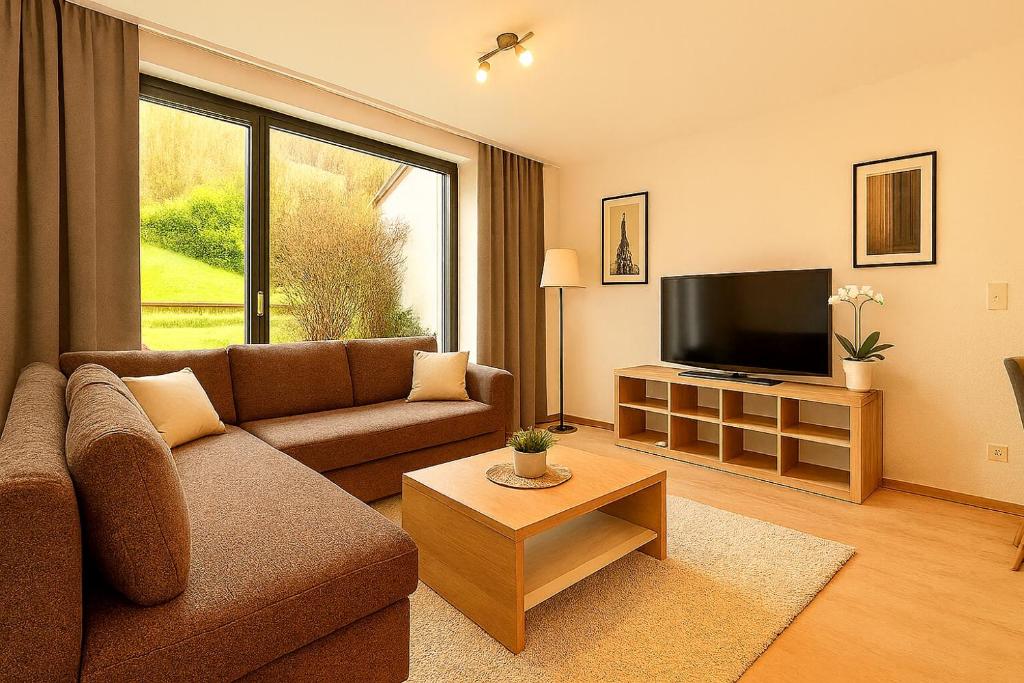 ein Wohnzimmer mit Couch und Flachbildfernseher in der Unterkunft Großes Ferienhaus in Siegen-Kreuztal auch für Monteure in Kreuztal