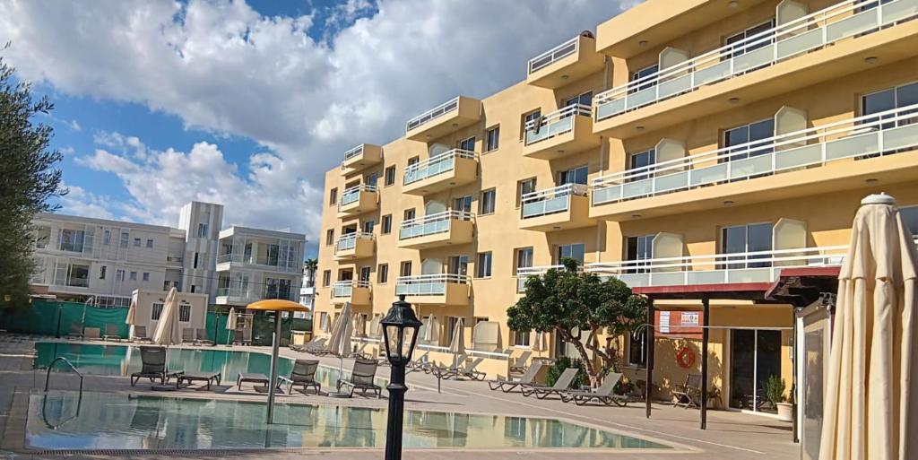 منتجع صنكويست غاردينز هوليداي في ليماسول: فندق به حمام سباحة أمام المبنى