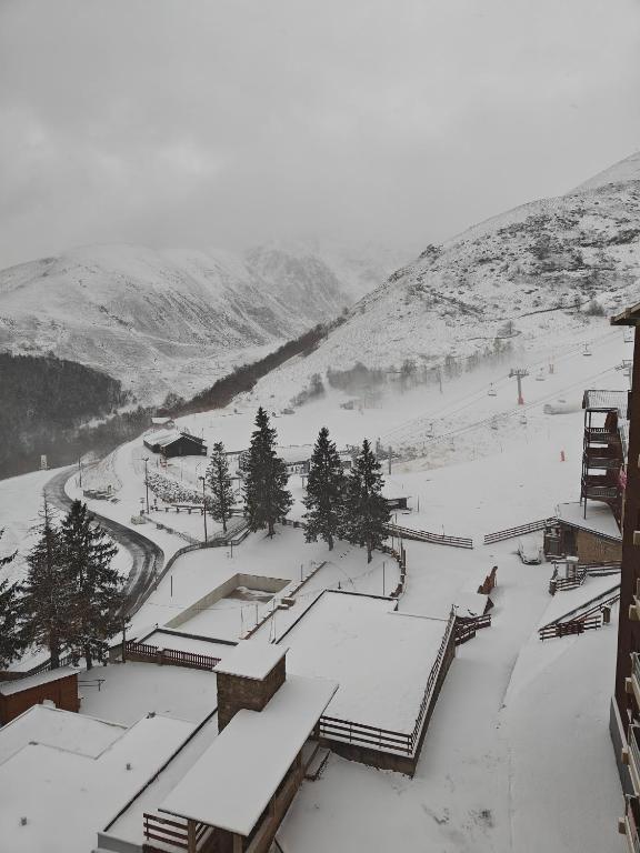 a snow covered ski slope with people skiing on it at Appartement Peyragudes les Agudes in Gouaux-de-Larboust