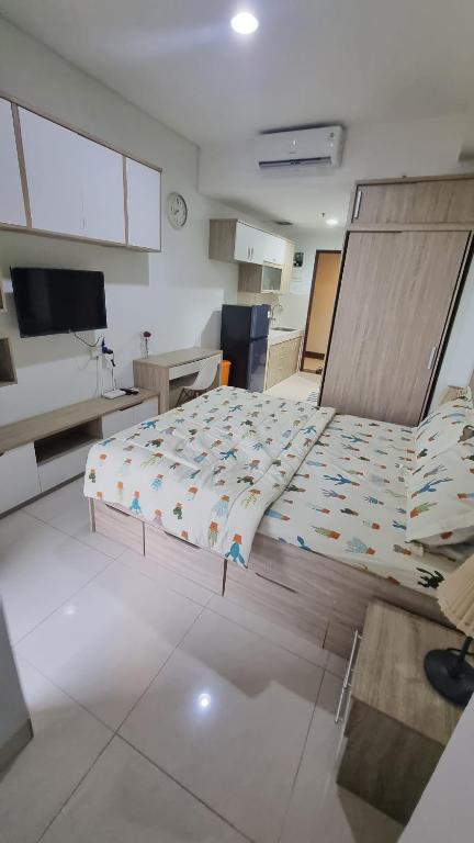 a bedroom with a large bed in a room at Apartemen Springwood by tuliproom in Pakulonan Dua