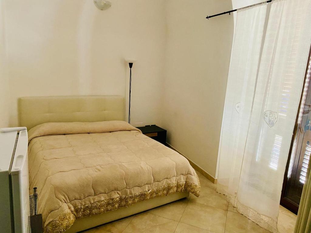 Un dormitorio con una cama en una habitación con ventana. en Armony B&B, en Bitritto