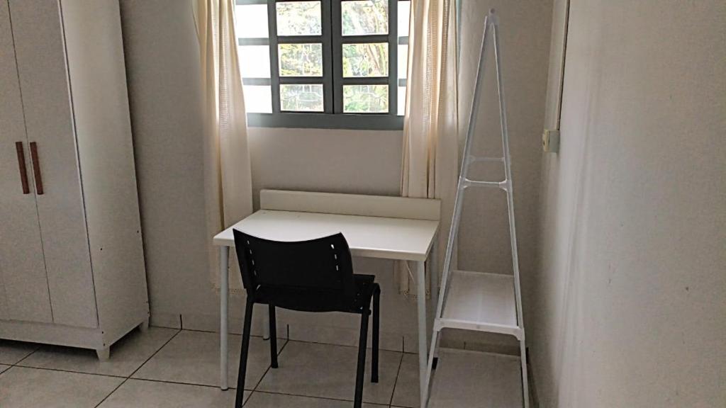 een wit bureau met een zwarte stoel en een ladder bij Dormitorio e WC privativo semanal in Valinhos