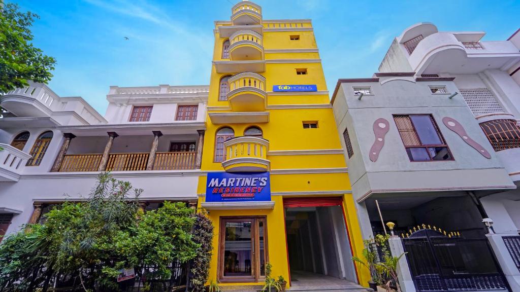 a yellow building with a sign in front of it at FabHotel Martine's Residency - French Colony, 5 Mins from Rock Beach in Puducherry