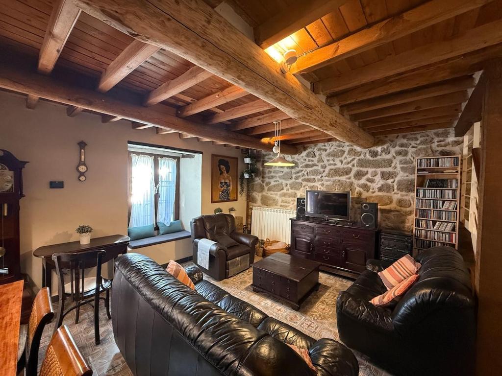 un salon avec un canapé en cuir et une table dans l'établissement Casa rural Fuente Santa, à Medinilla