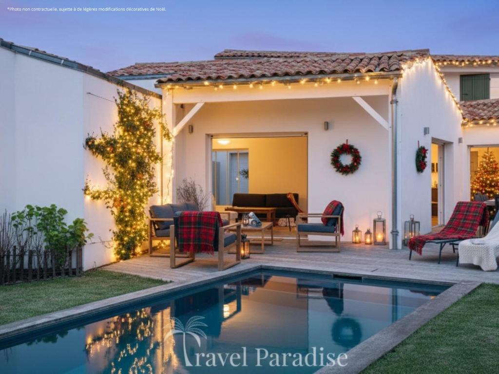 une terrasse avec une piscine en face d'une maison dans l'établissement Villa Blanche, à Rivedoux-Plage