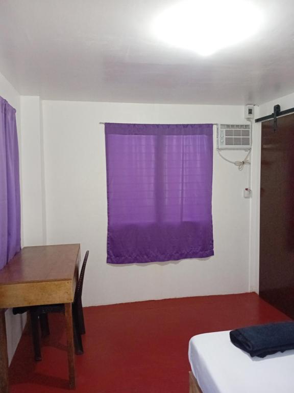 um quarto com uma cortina roxa e uma mesa em burgos em San Isidro