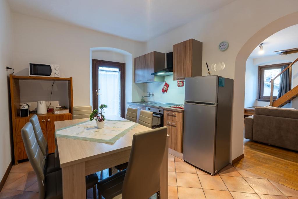 a kitchen and dining room with a table and a refrigerator at GolfHouseApartment in Bocenago