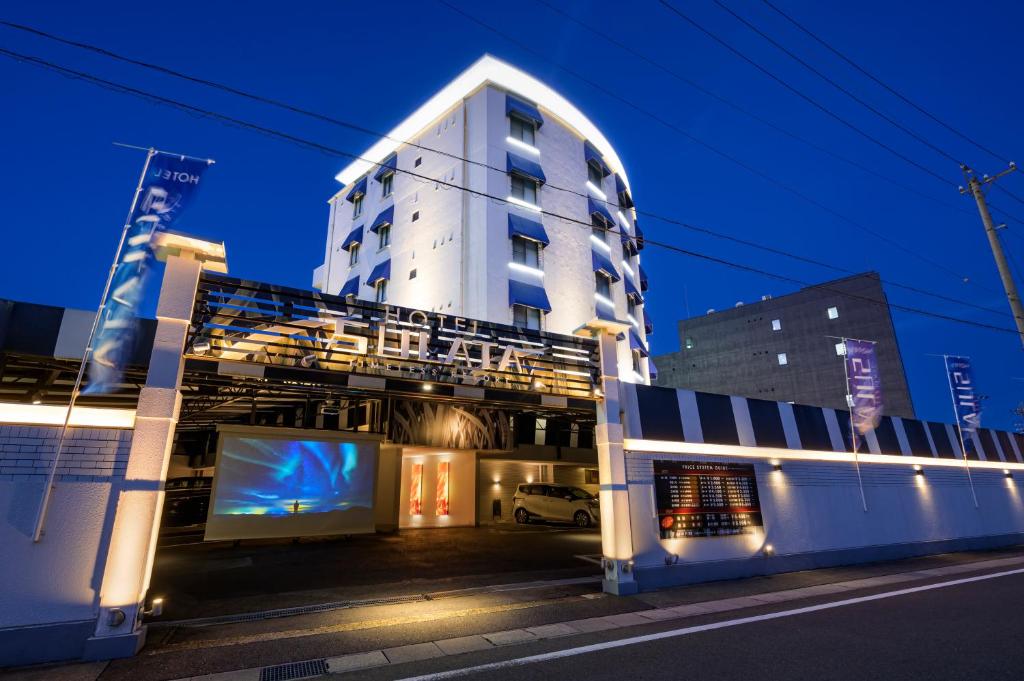 a tall white building with a tv in front of it at HOTEL SULATA GIFU HASHIMA (Adult Only) in Hashima