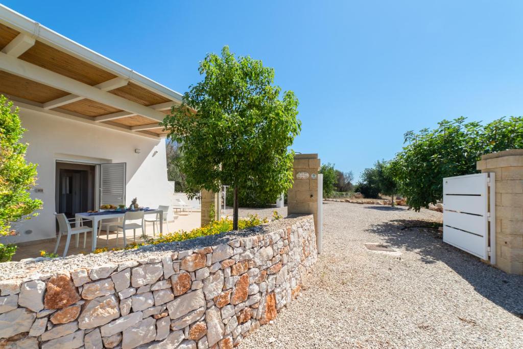 佩斯科勒海滨Villa Lantana by SALENTOLTREMARE的房子前面的石墙