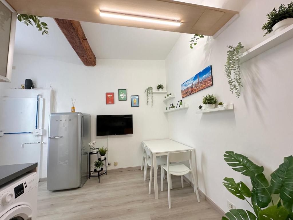una cucina bianca con tavolo e frigorifero di Mondo House a Bologna