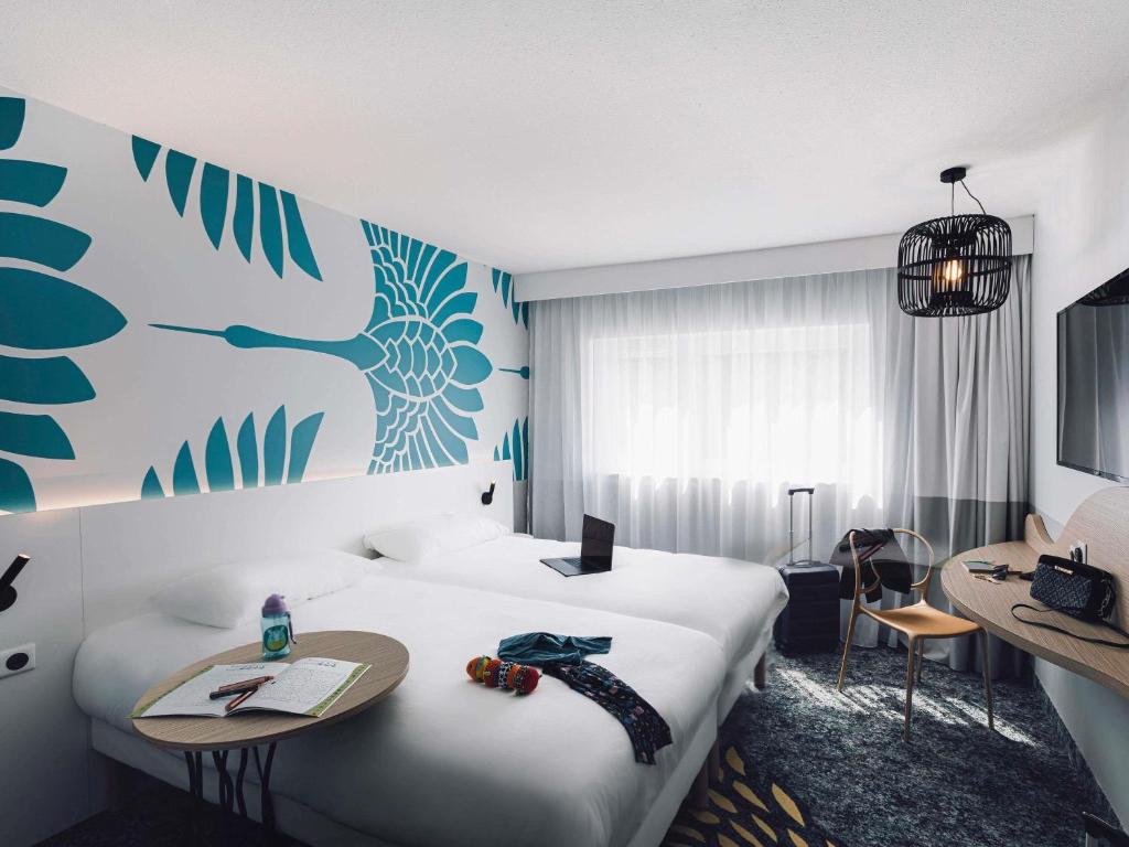 a hotel room with a large bed and a desk at ibis Styles Nancy Laxou in Nancy