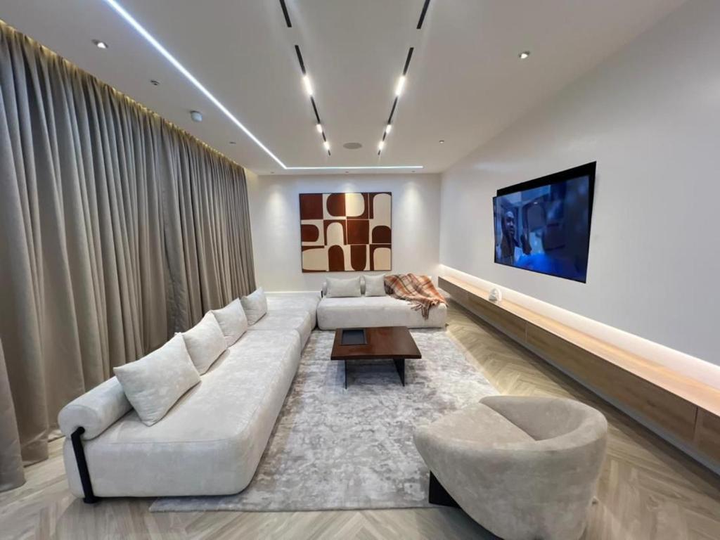 un soggiorno con un divano e una TV di Chizzly Apartment a Bamgbose