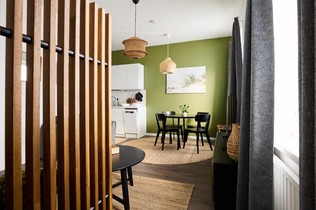 Una cocina y comedor con paredes verdes y una mesa. en Renovated 1BR Apt in Turku Downtown with Best Location, en Turku