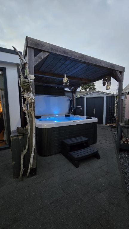 a hot tub sitting on top of a patio at Chalet 138 lodge in Sint Annaland