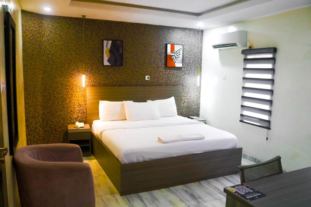 拉各斯House 32 Hotels and Suites的一间卧室，配有一张床、一张桌子和一把椅子