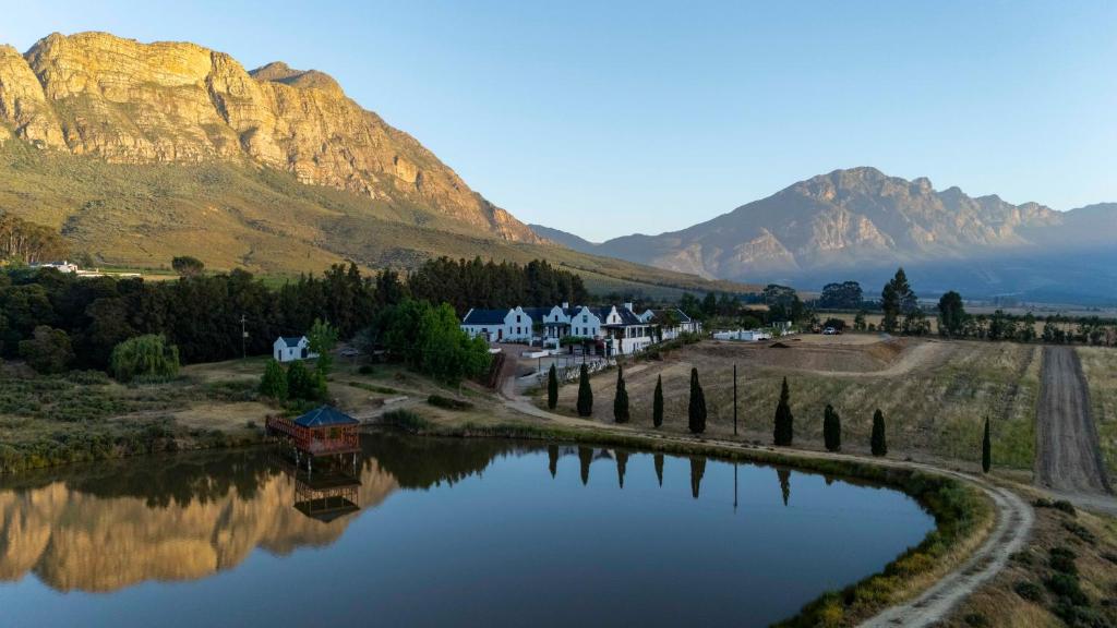 een meer met huizen en bergen op de achtergrond bij Diggers Country House in Tulbagh