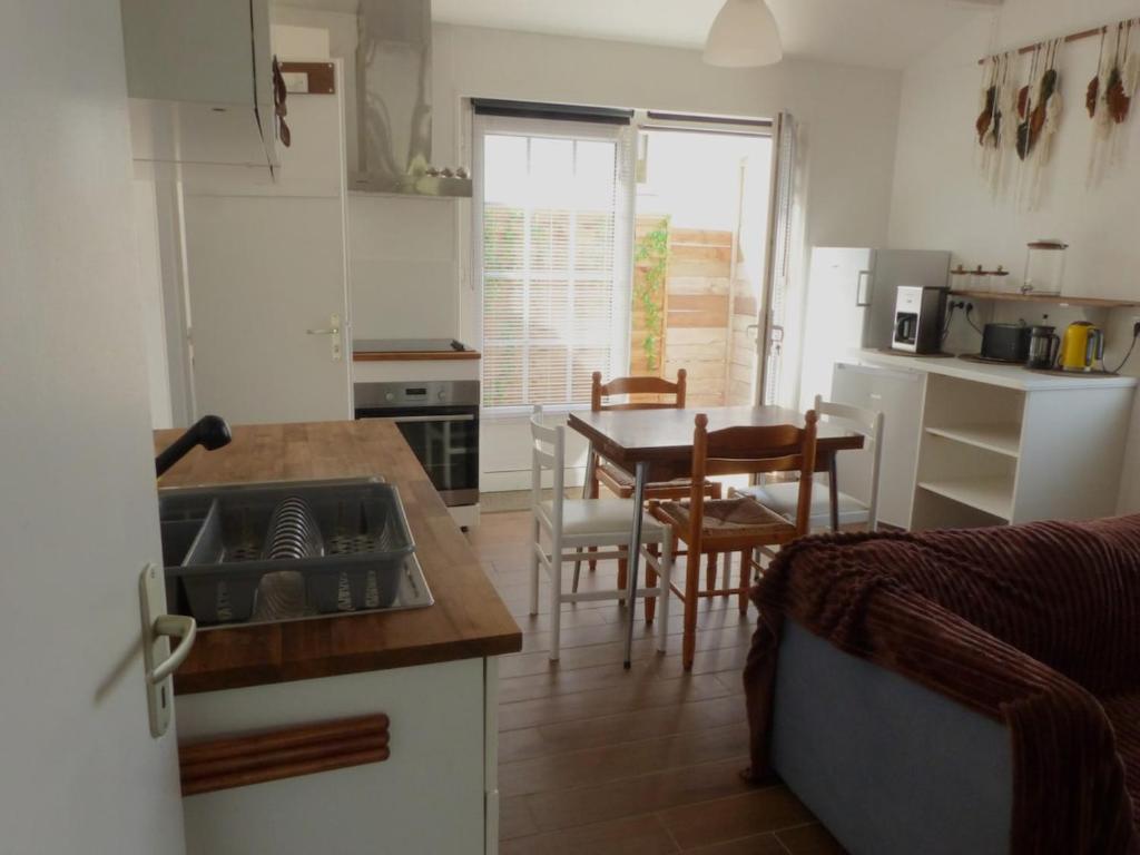 a kitchen and dining room with a table and chairs at Séjour indépendant et autonome chez l'habitant avec petit-déjeuner inclus in L'Ile d'Yeu