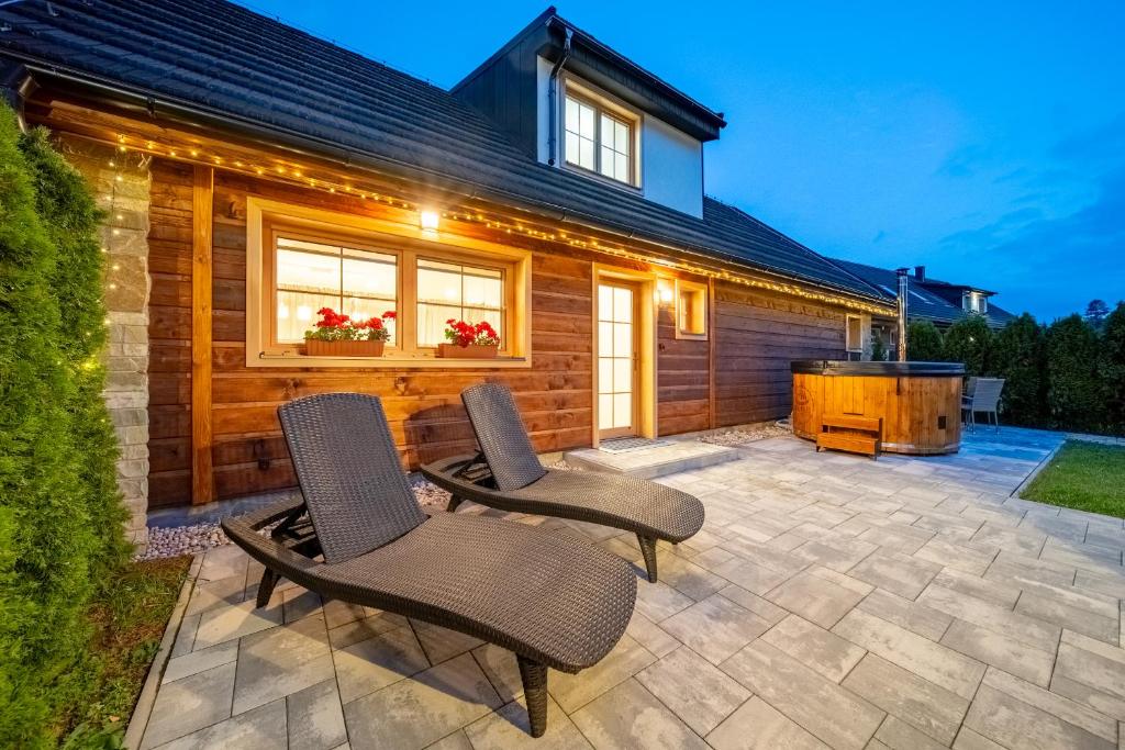 a patio with two chairs and a hot tub at Chata Pinea in Zuberec