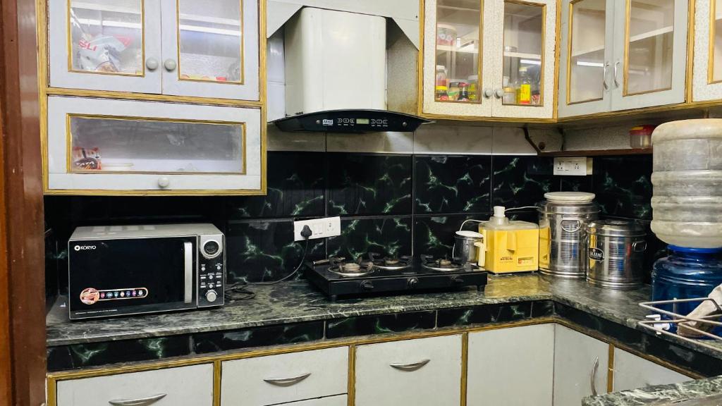 a kitchen with a counter top with a microwave at Gavari India's Delhi Hostel in New Delhi