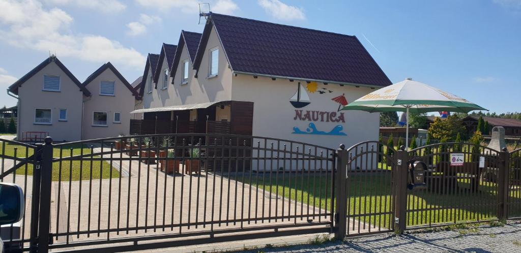 a building with a black fence and an umbrella at Nautica in Gąski