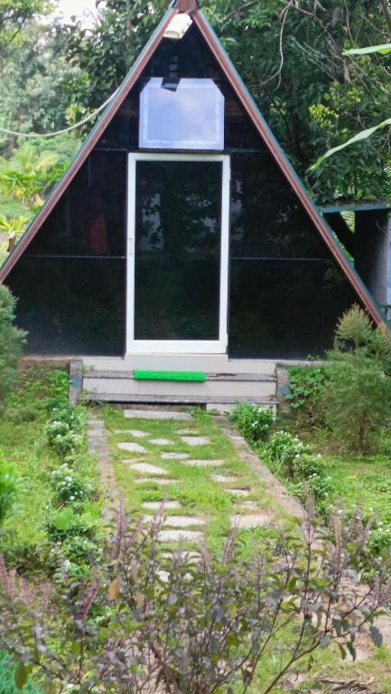 a doghouse with a window in a yard at Manna Homestay coorg in Kushālnagar