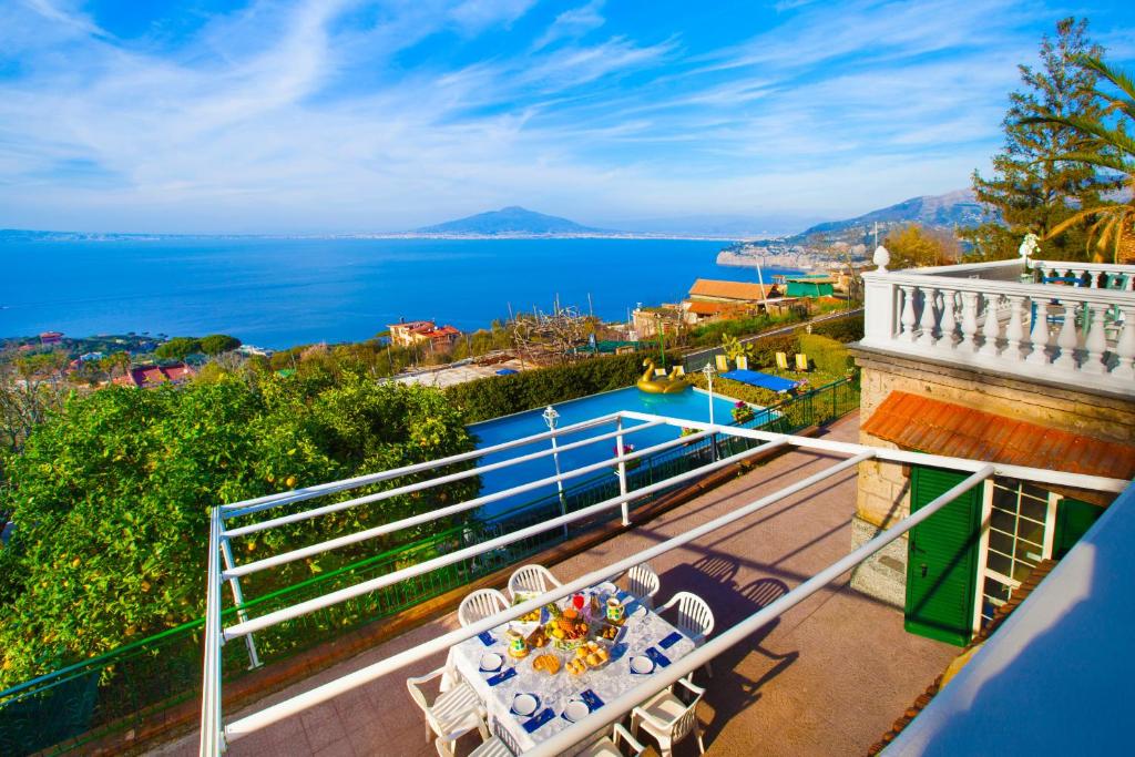 a balcony with a table and a view of the water at Estate4home - Villa Luisa Jacuzzi&Pool in SantʼAgata sui Due Golfi