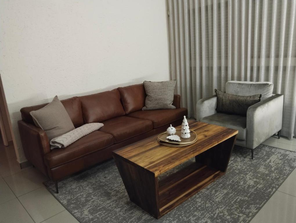 a living room with a brown couch and a coffee table at Melkbos Corner in Witbank