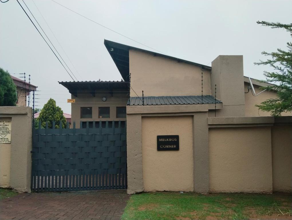 a house with a gate with a sign on it at Melkbos Corner in eMalahleni