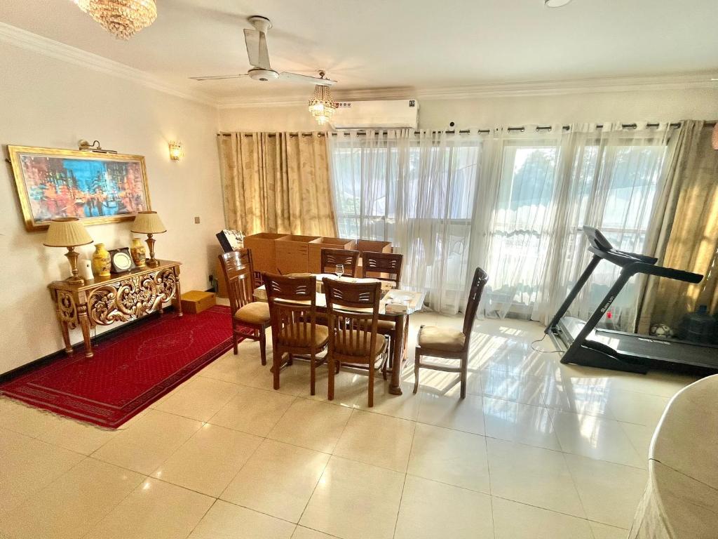 een woonkamer met een eettafel en stoelen bij Beautiful Apartment in Islamabad