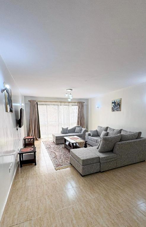 a living room with a couch and a table at Comfort meets convenience 3BR by Airport & SGR in Nairobi