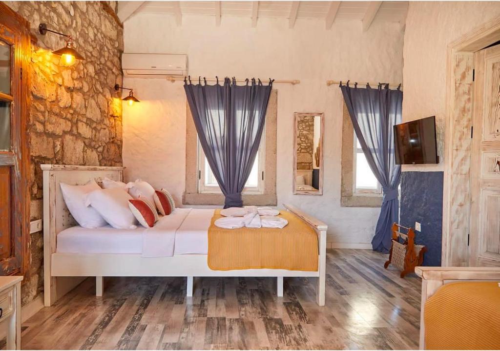 阿拉恰特MorisiAvluAlaçatı的一间卧室配有白色的床和蓝色窗帘