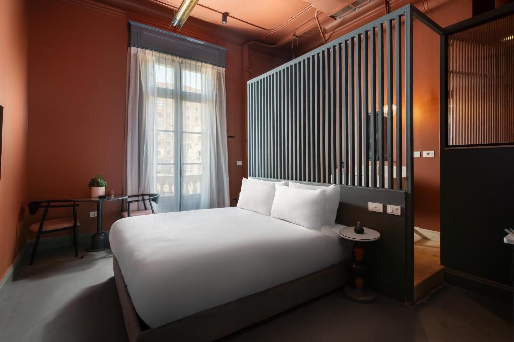a bedroom with a bed with white sheets and a window at grey l studio apartments Downtown Cairo Bidair House in Cairo