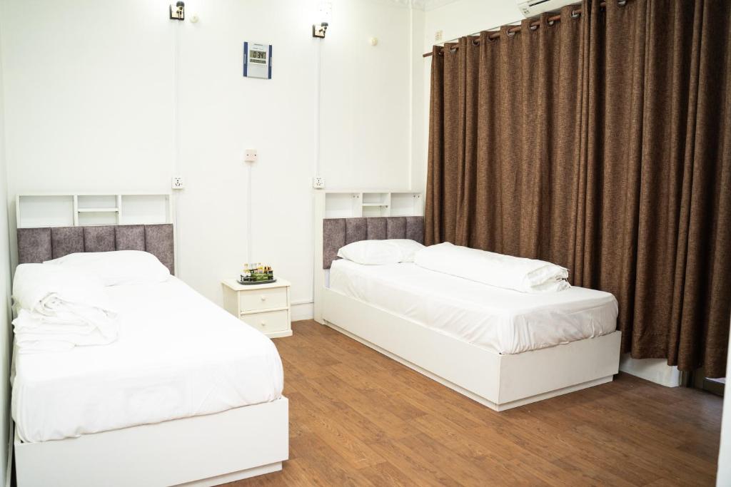 a bedroom with two beds and a window at Aarya Wellness & Hostel in Kathmandu